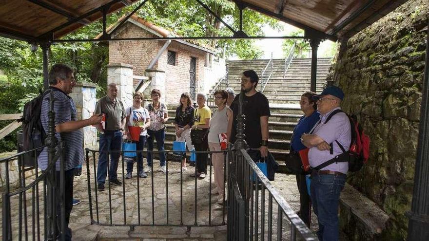 Miguel Ángel Fernández, a la izquierda, habla con algunos de los participantes, en la fuente del Güevu, en Lada.