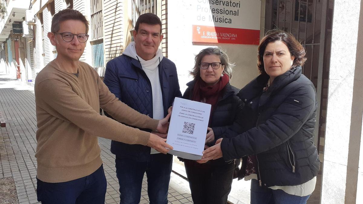Responsables del conservatorio sostienen la caja con las firmas