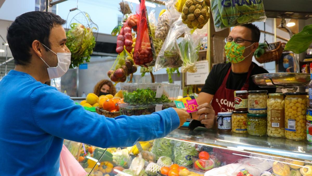 Compra con la tarjeta en el mercado municipal.