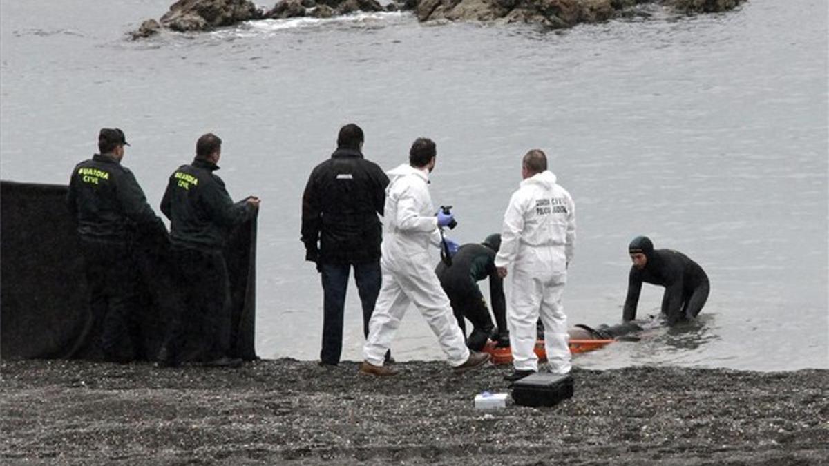 Agentes de la Guardia Civil recogen el cadáver de un inmigrante subsahariano en aguas de Ceuta el pasado día 12.