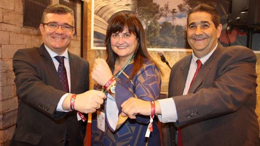 El alcalde y el edil de Turismo de Arganda del Rey, Guillermo Hita e Irenio Vara, flanquean a la alcaldesa de Carreño, Amelia Fernández, mostrando las pulseras de la campaña &quot;Late Candás&quot;.