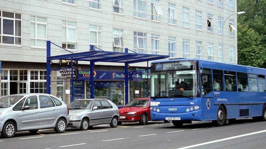 Un autobús interurbano junto a una parada en O Burgo.
