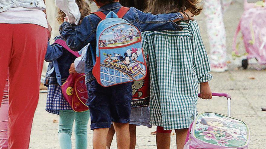 Una madre lleva a sus hijos al colegio.