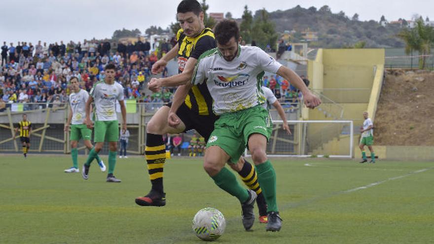 Santi, del Villa, protege el balón ante un rival del Rápido de Bouzas