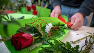 Un florista preparando una rosa para ser vendida en Sant Jordi.