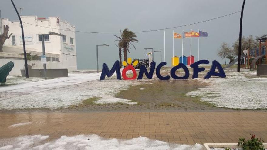 Las letras turísticas de Moncofa rodeadas del blanco del granizo