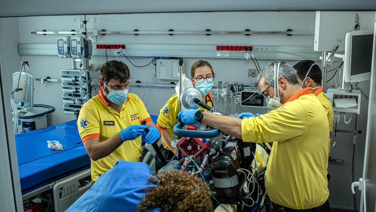 Pla mitjà de professionals del SEM treballant amb un pacient crític complex gràcies a una UCI mòbil.