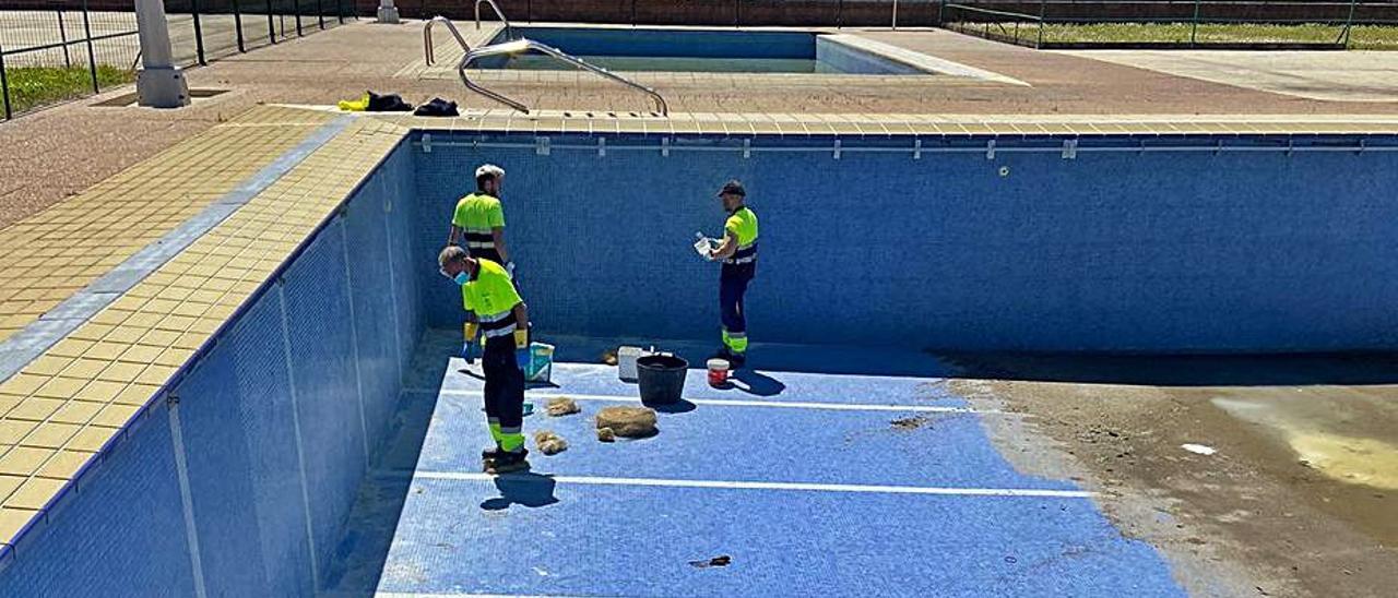 Tres operarios trabajan en el vaso de la piscina. | S. Arias