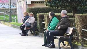 Una pareja de jubilados sentados en un banco.