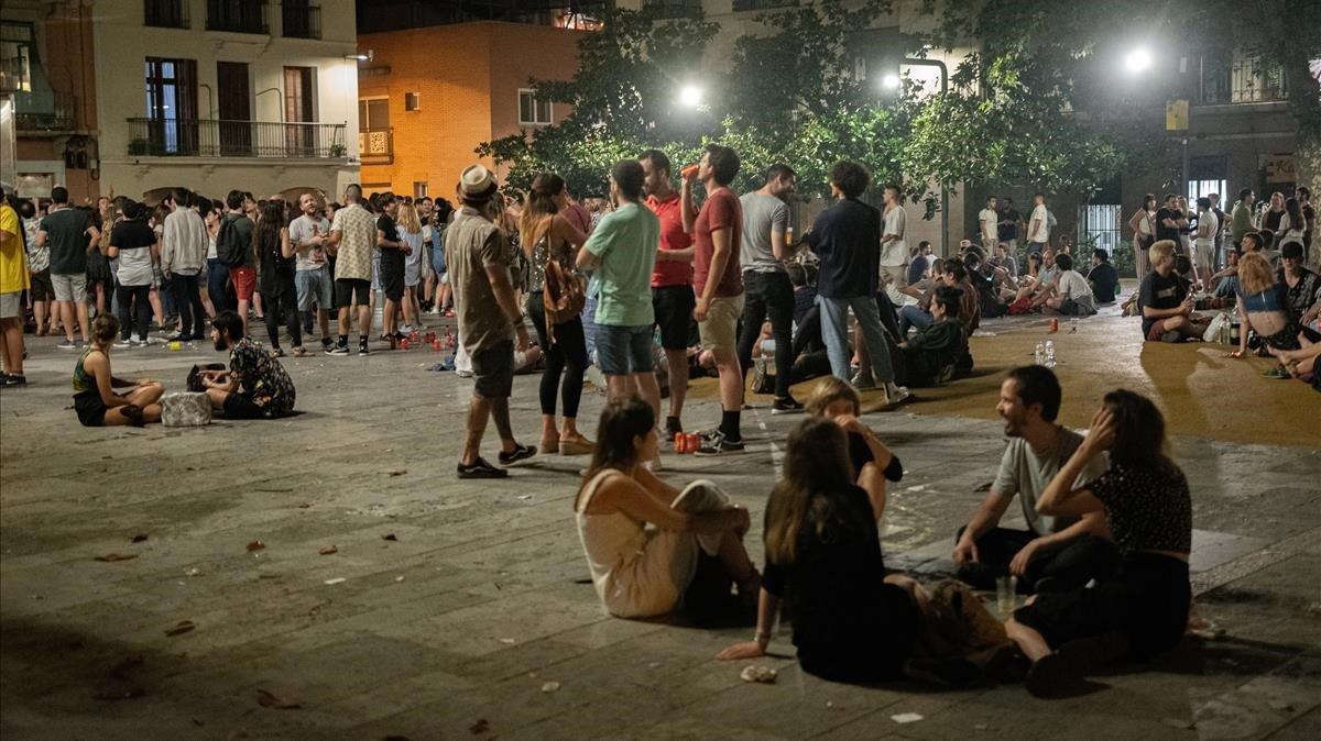 Jóvenes en una de las plazas del barrio de Gràcia, durante la verbena.