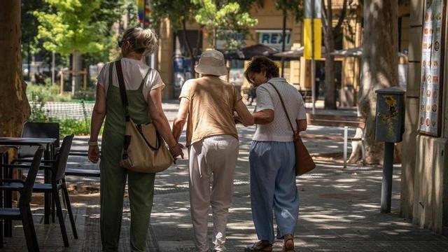 Tres persones passegen pels carrers de Barcelona durant l’onada de calor.