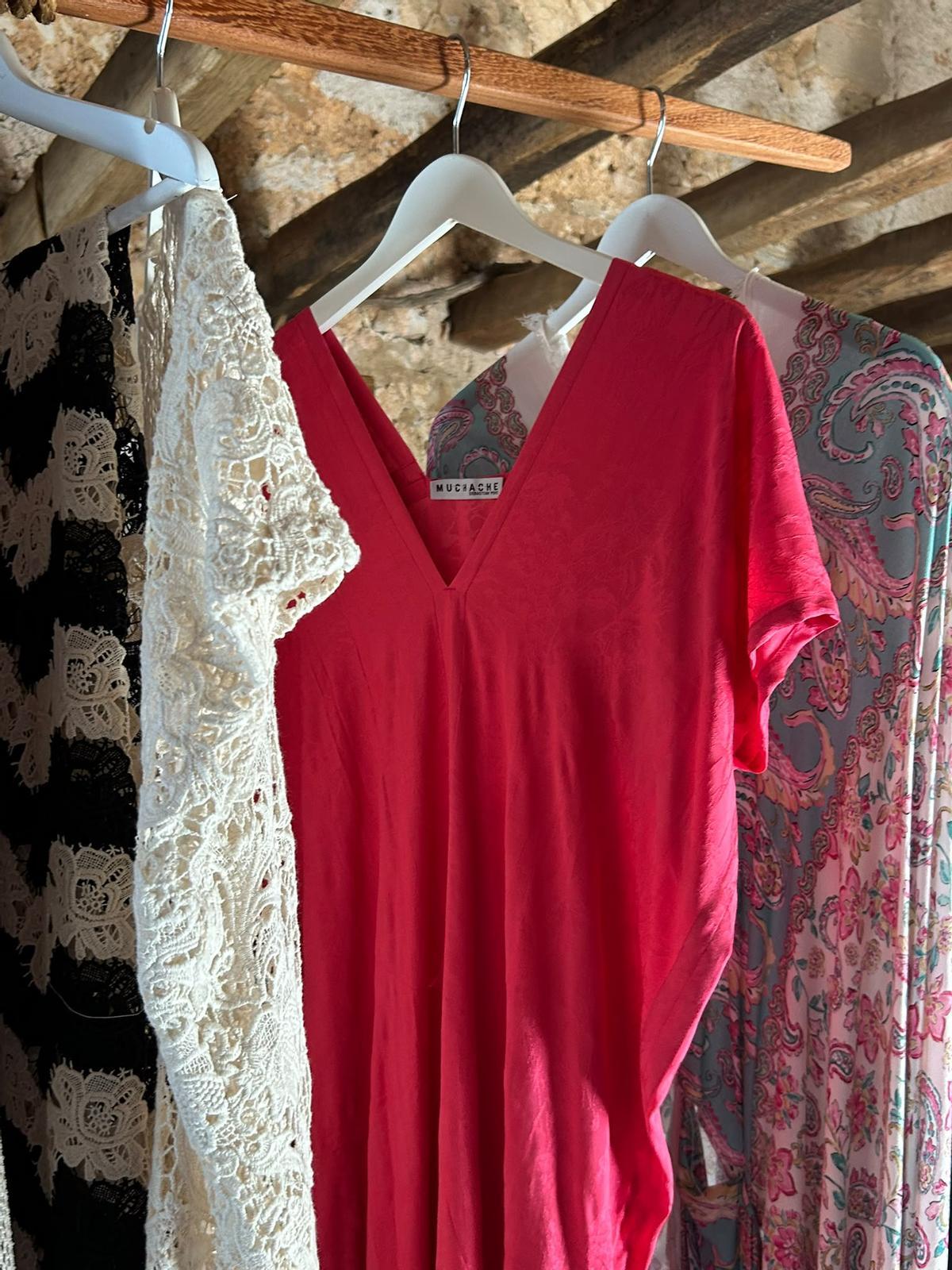 Ropa confeccionada junto a las telas colgadas en perchas