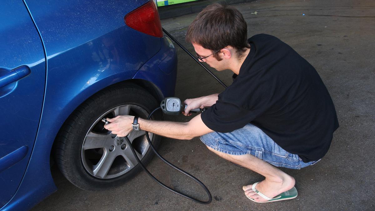 Un hombre hincha una rueda en una gasolinera de Barcelona