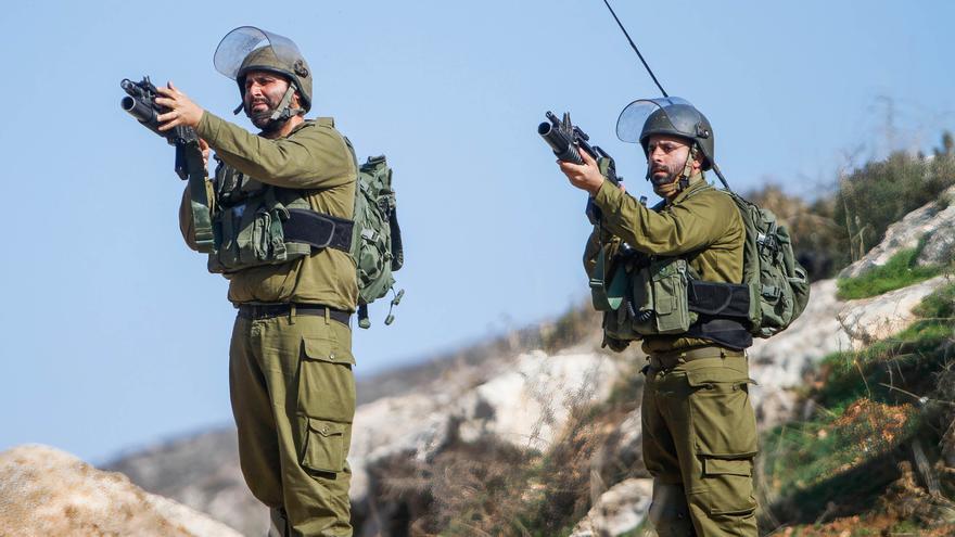 Soldados israelíes apuntan con sus armas a los manifestantes palestinos durante una manifestación contra los asentamientos israelíes en el pueblo de Beit Dajan, cerca de la ciudad cisjordana de Nablús.