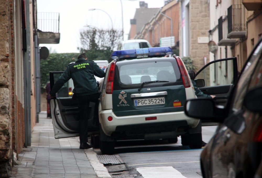 Dos agents de la Guàrdia Civil pujant al vehicle policial durant l'operatiu al carrer Pujades de Figueres