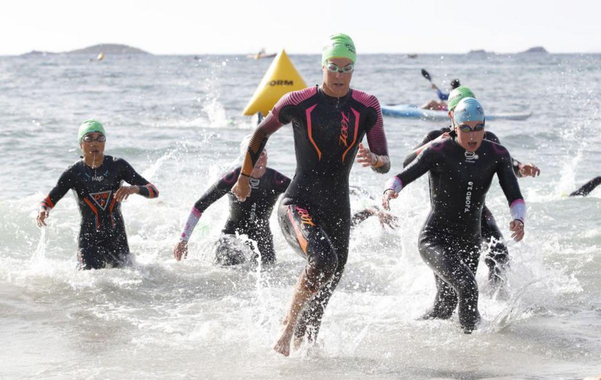 Un grupo de triatletas saliendo del agua. | J.A.RIERA