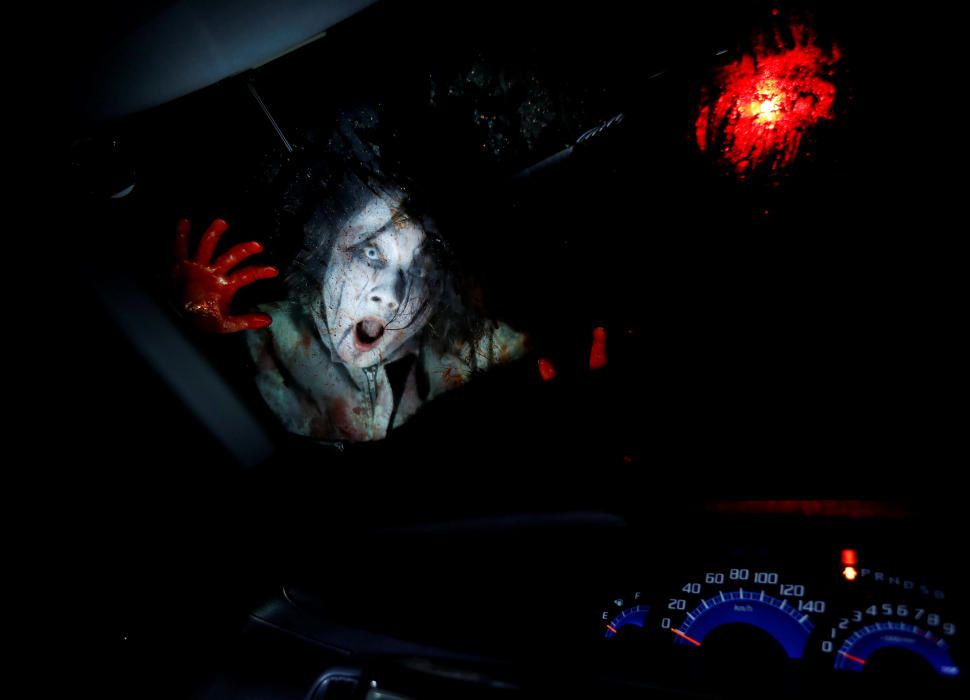 An actor dressed as a zombie performs during a ...