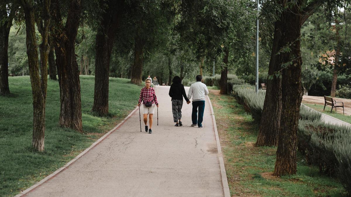 Varios vecinos pasean por el bulevar de la Avenida de Almendros que cruza Rivas Vaciamadrid