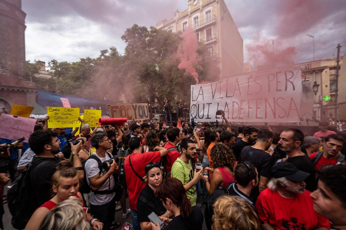 Miembros de las 'colles' de Gràcia abren botes de humo durante la protesta en el pregón de fiestas contra el veto a los 'correfocs' y otros actos de cultura popular.