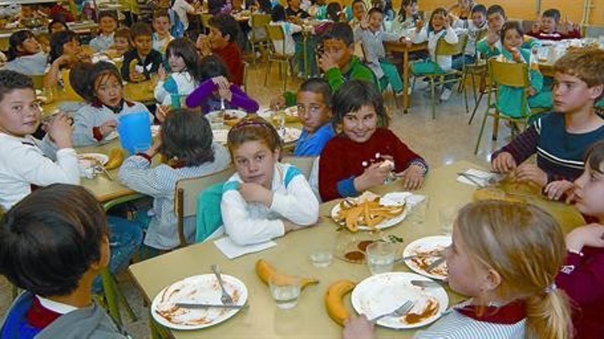 Decenas de niños degustan sus menús en el comedor de la escuela Ferreries.