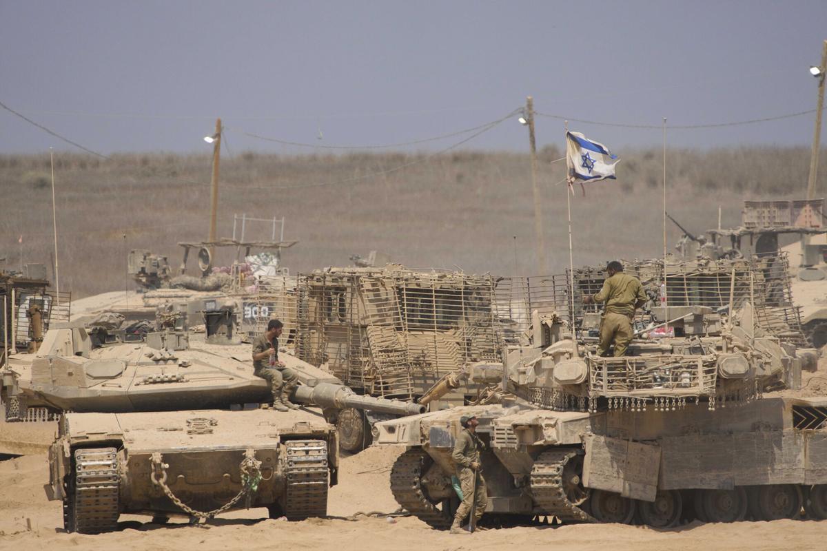 Soldados israelíes trabajan en sus tanques en una zona de concentración en la frontera con la Franja de Gaza.