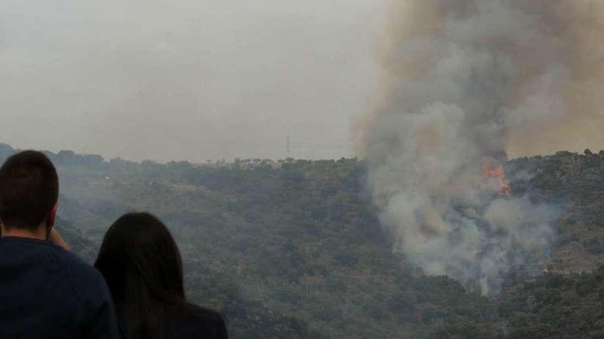 Dos jóvenes observan el ascenso del fuego hacia Fermoselle en la mañana del primer encierro.