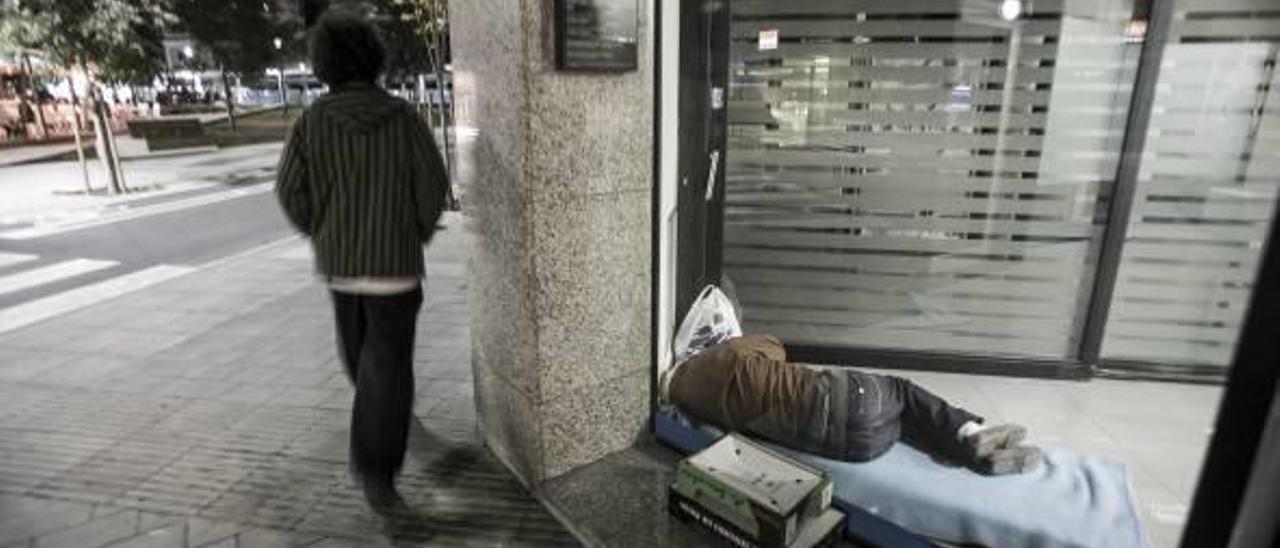 Dos personas sin techo se refugian en los cajeros de la ciudad para cobijarse del frío y poder dormir.