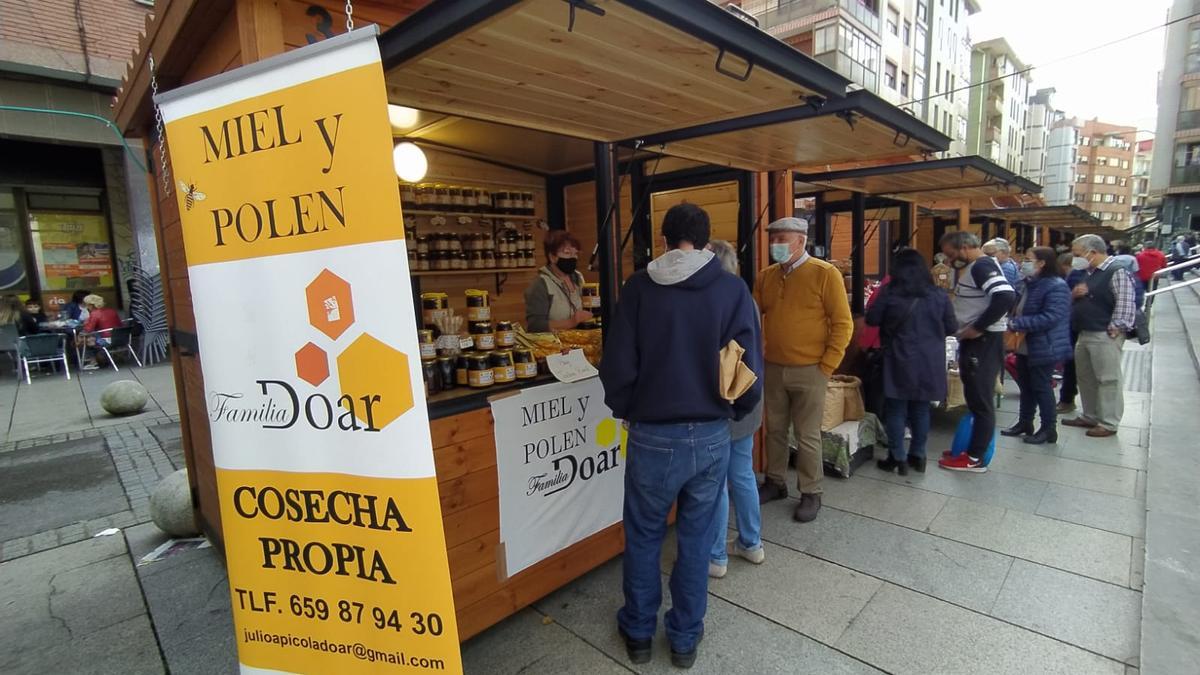 Varias personas visitan los stands instalados para la feria con productos del Valle del Alagón, en Astrabudúa.