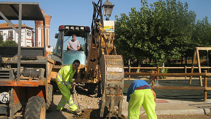 Varios operarios realizan trabajos para la instalación de farolas en la avenida de la Constitución de Santa Cristina.