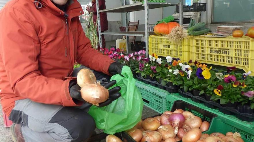 Miguel Martínez, con unas cebollas, ayer, en el mercado.