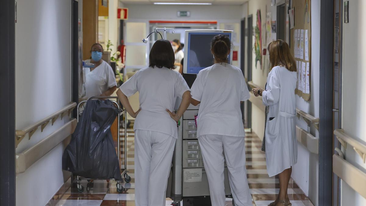 Trabajadores de la sanidad pública en el pasillo de un gran hospital valenciano.