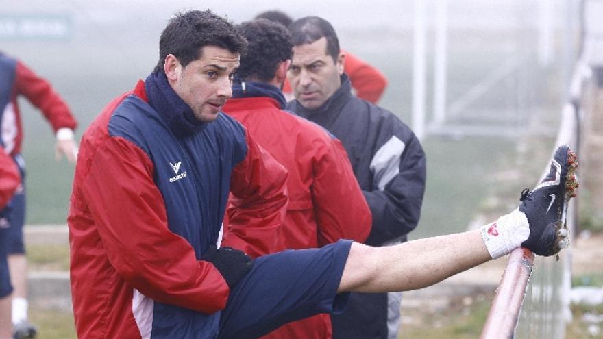 Iván García estira mientras Tomé habla con Agustín en el entrenamiento