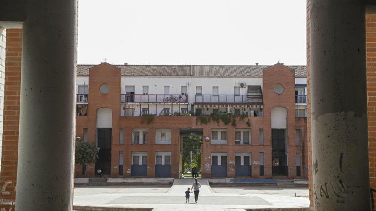 Una mujer y su hijo caminan entre bloques de viviendas en el barrio de Moreras.