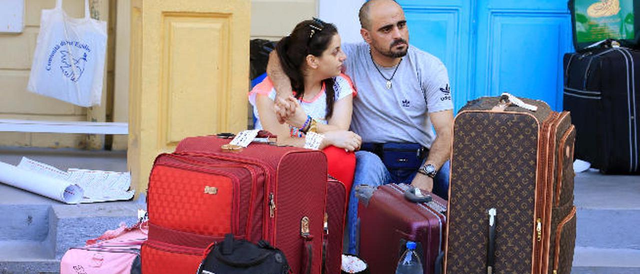 Una pareja de sirios en Líbano, junto a su equipaje, espera para ir al aeropuerto.