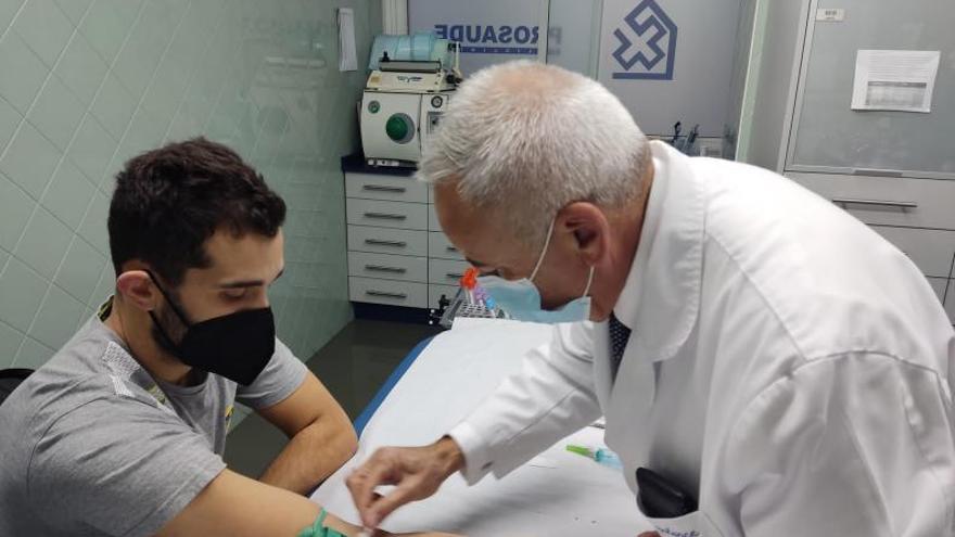 Uno de los médicos extrae muestras de sangre a Adrián Menduíña. |  // GONZALO NÚÑEZ