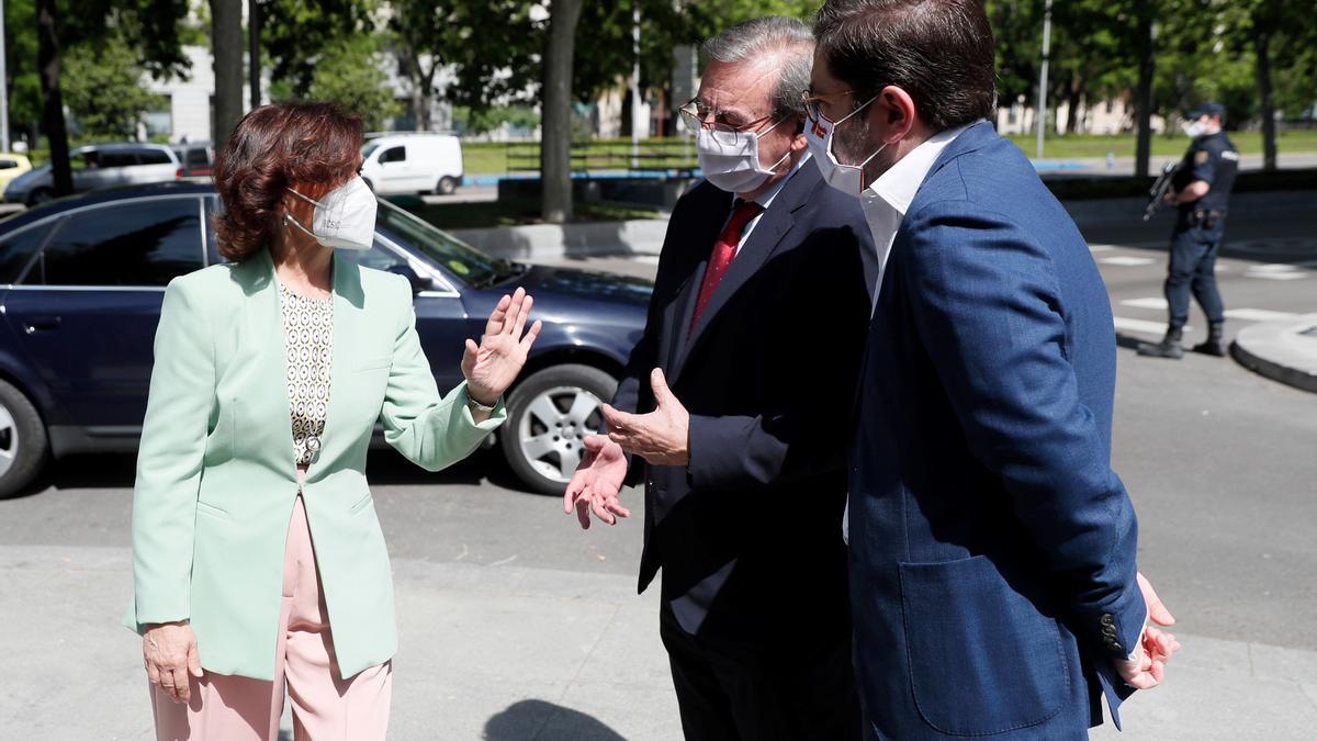 La vicepresidenta primera del Gobierno, Carmen Calvo, saluda al secretario de Estado de Memoria Democrática, Fernando Martínez (2d), y al secretario de Estado de España Global, Manuel Muñiz (d), a su llegada al acto de Estado en recuerdo y homenaje al exilio español, este 8 de mayo en la Casa de América de Madrid.