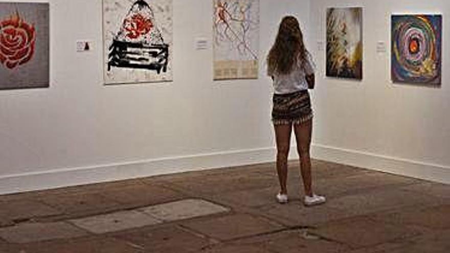 Una joven contempla algunos de los cuadros.