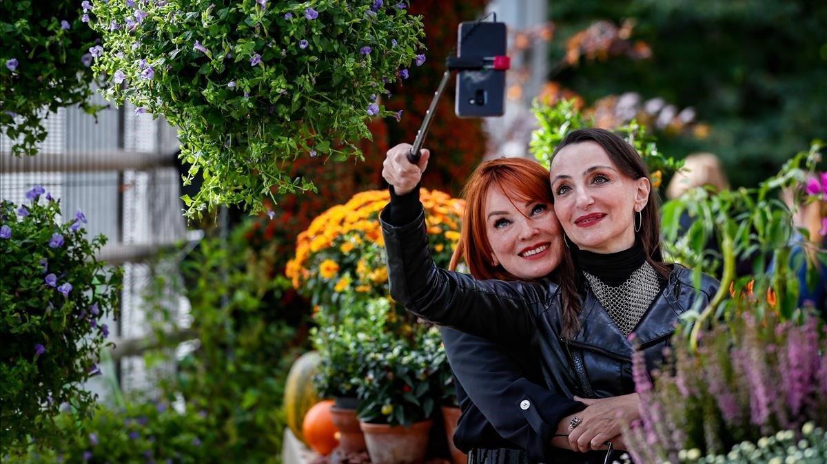 Dos mujeres se hacen una foto durante la celebración del festival Colores del Otoño en el jardín botánico de Moscú.