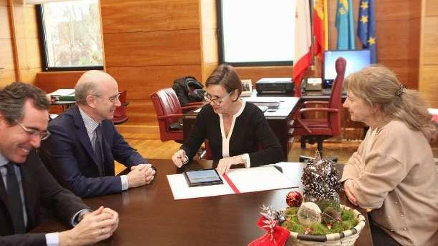 Carmen Moriyón, en el centro, durante la firma del convenio de colaboración con el Colegio de Veterinarios de Asturias.