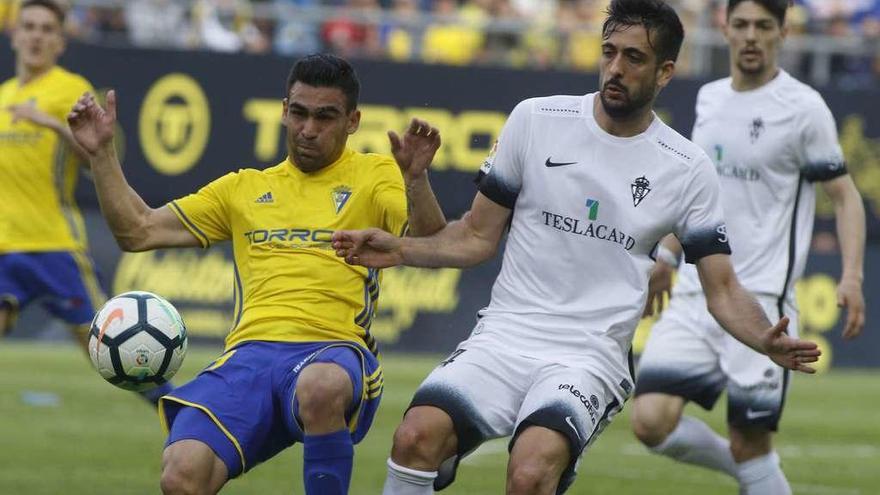 Álex Pérez pelea por un balón con Romera ante la mirada de Barba.