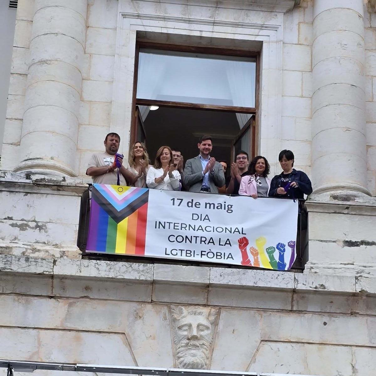 Autoridades y representantes de colectivos en la exhibición de una pancarta en el balcón del Ayuntamiento de Gandia