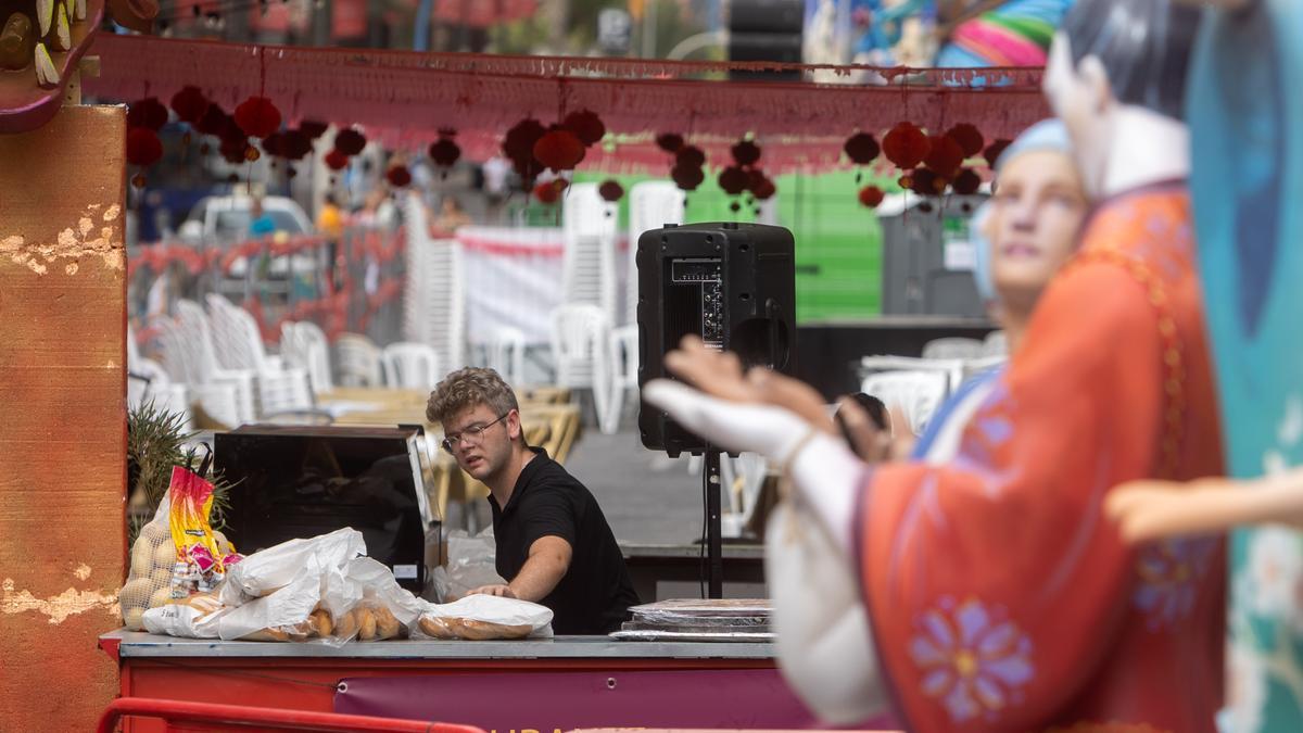 Un trabajador de una barraca prepara la comida para servir en fiestas