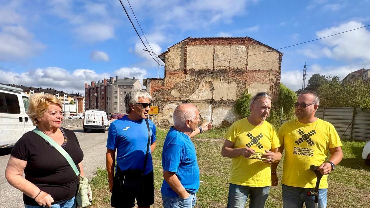 Julio Fueyo, en el centro, junto a vecinos del barrio de El Puente y representantes de la plataforma por el soterramiento