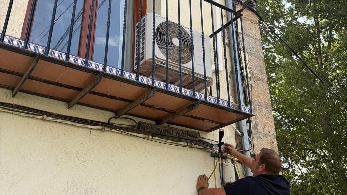 Un técnico instala aire acondicionado en una casa de Morella.