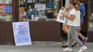 Una familia pasa por delante de un comercio durante la campaña de la vuelta al cole 2023