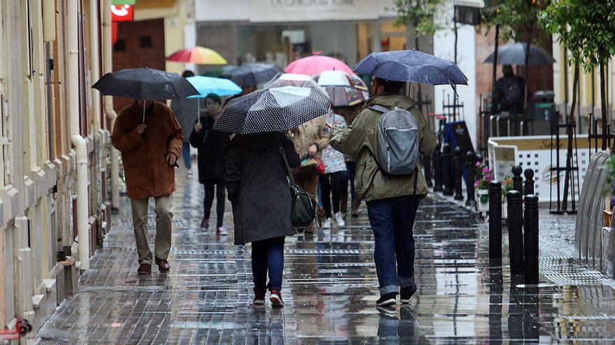 Varias personas caminan bajo la lluvia en Málaga.