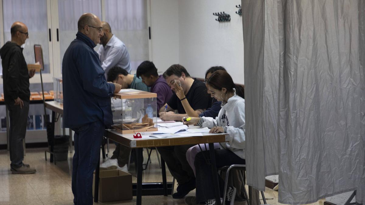 Dos electores depositan su voto en las urnas este domingo