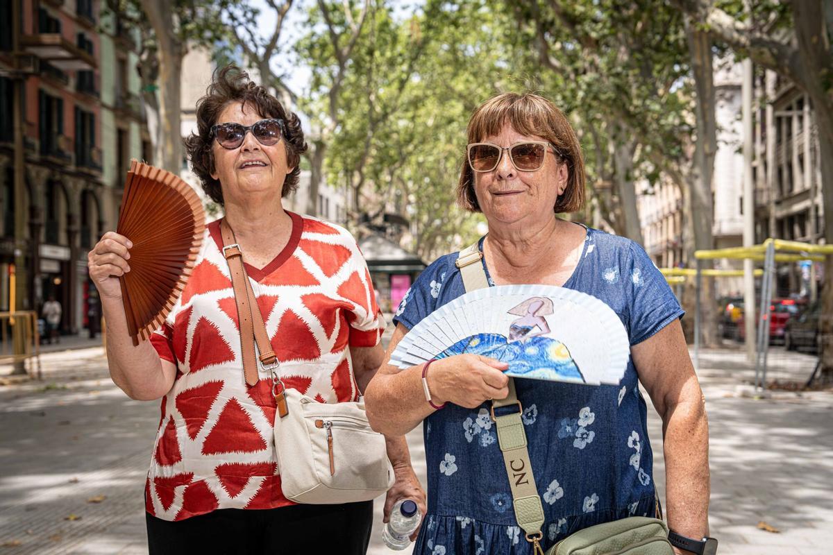 Gente abanicándose en otra jornada marcada por el pico de calor en Barcelona.