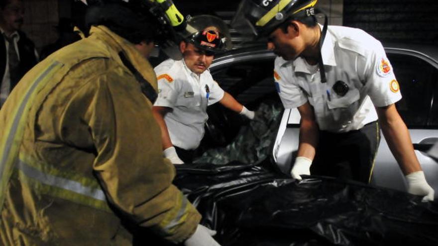 Voluntarios de Bomberos transportan el cuerpo sin vida del periodista Rolando Ardami Santis de León, de 42 años, quien resultara muerto tras un atentado perpetrado por dos hombres con cascos en Ciudad de Guatemala (Guatemala).