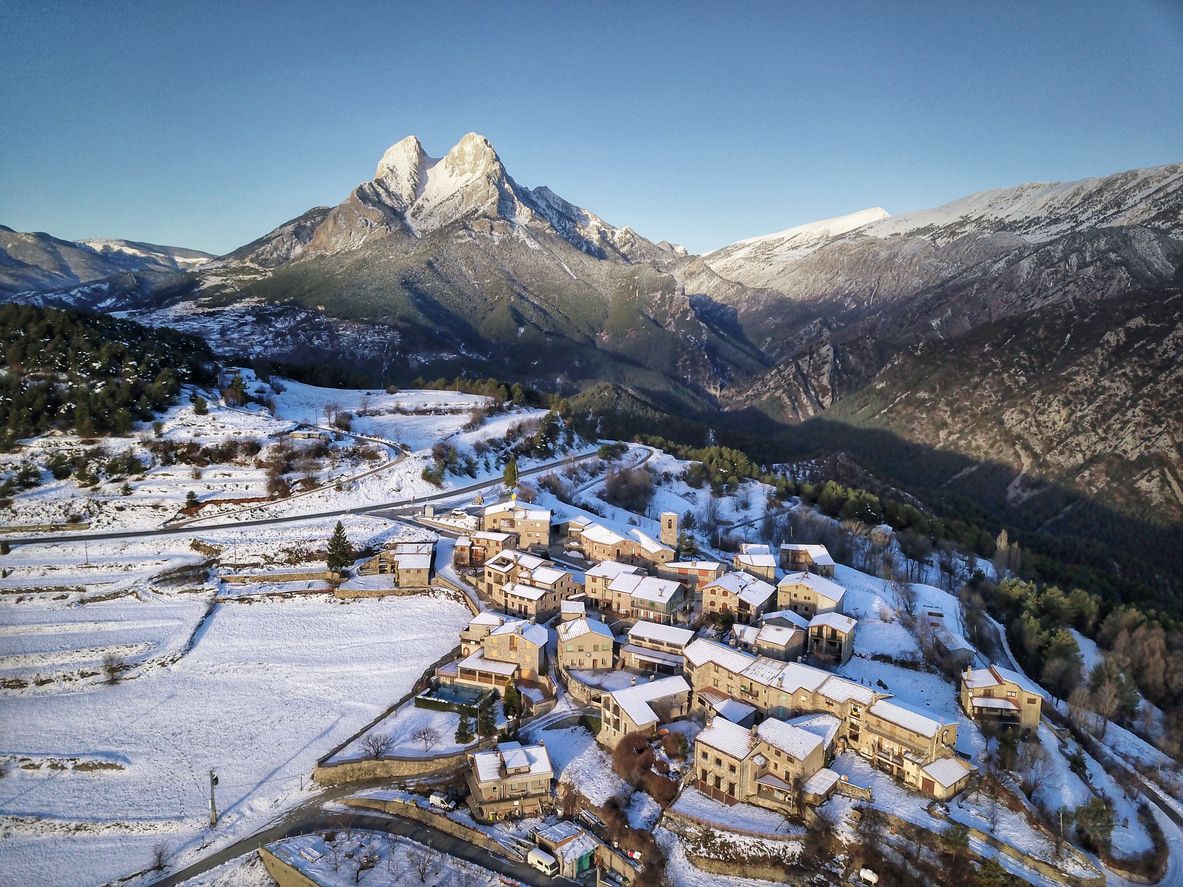 Un pueblo nevado delante de la montaña del Pedraforca